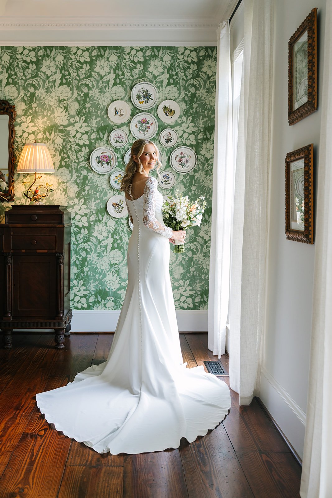 Dylan & Emelia wedding — bride with bouquet by the window